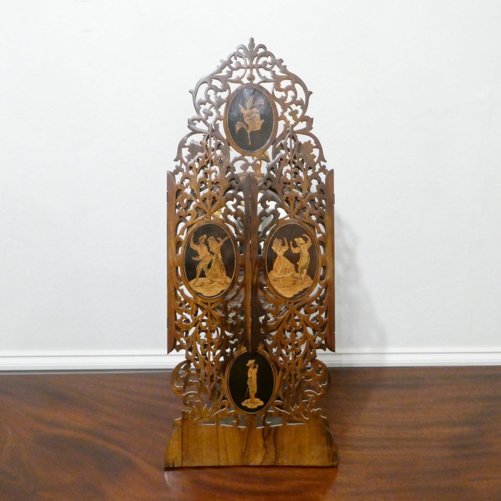 A fretted walnut triptych dressing table mirror featuring central oval glass plates surrounded by openwork carved scroll patterns and inlaid timber panels. View III