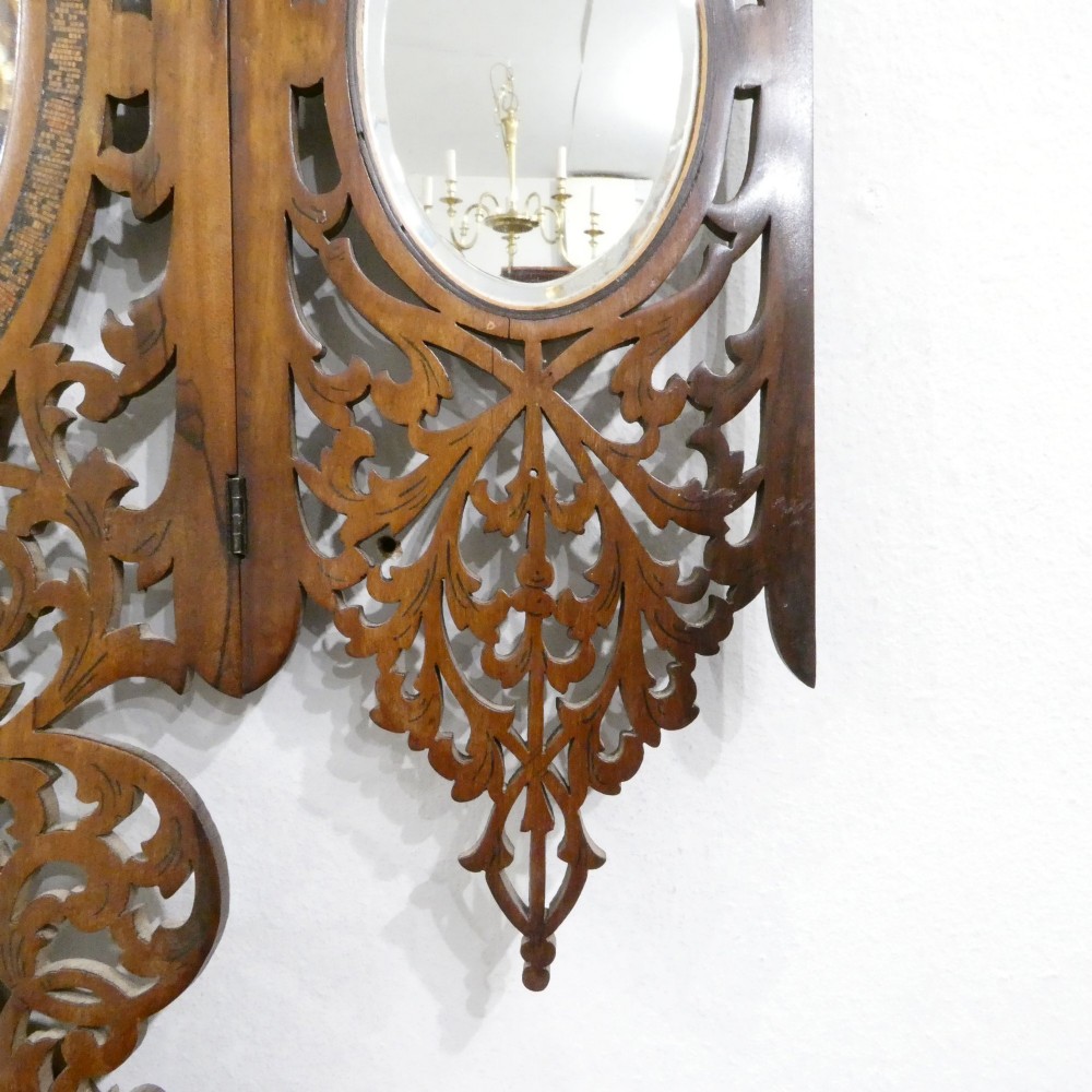 A fretted walnut triptych dressing table mirror featuring central oval glass plates surrounded by openwork carved scroll patterns and inlaid timber panels. View XI