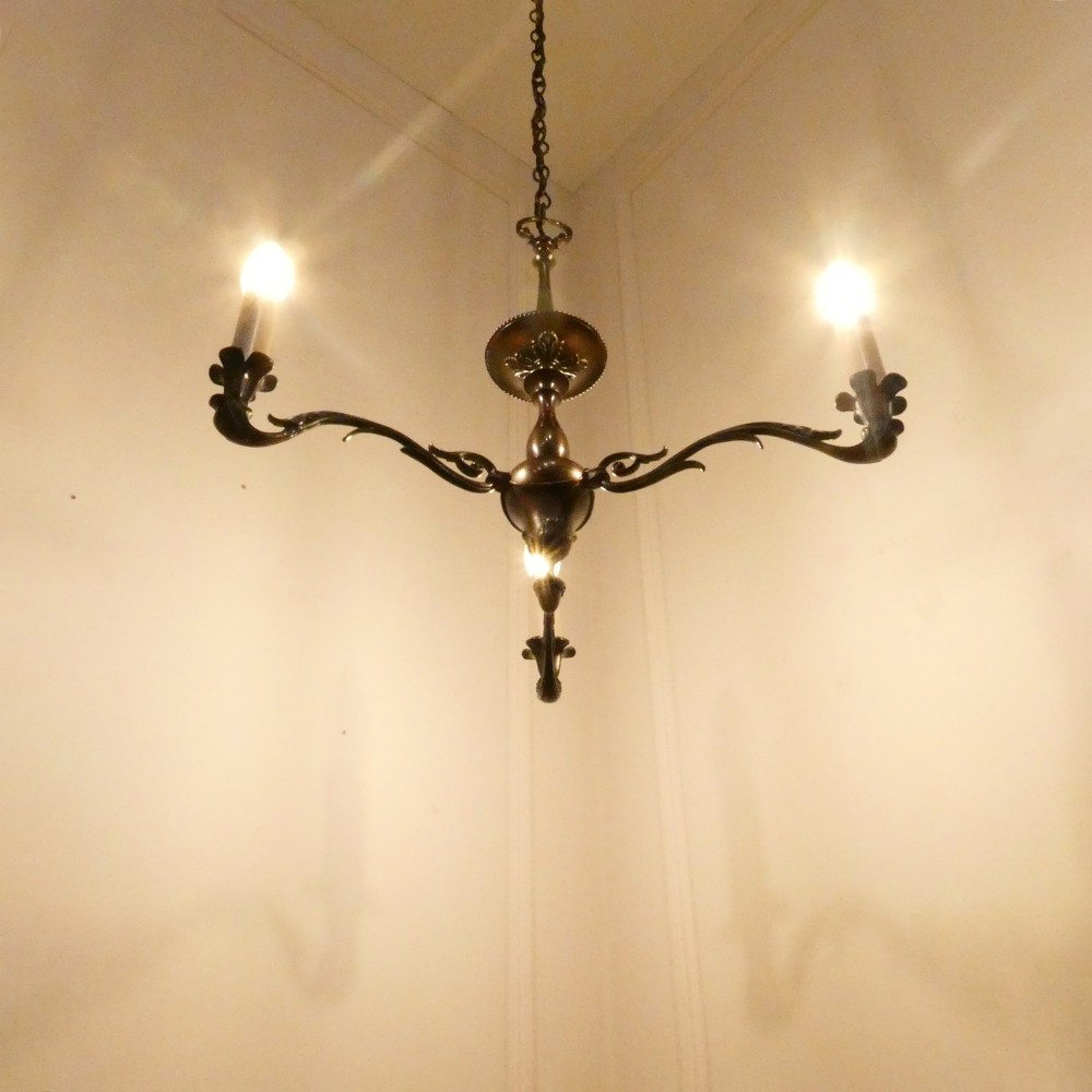 An early 20th-century Dutch bronze two-light chandelier featuring a baluster-turned central stem and curved scrolling arms. View III