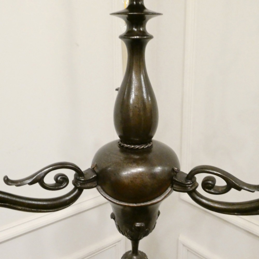 An early 20th-century Dutch bronze two-light chandelier featuring a baluster-turned central stem and curved scrolling arms. View VI