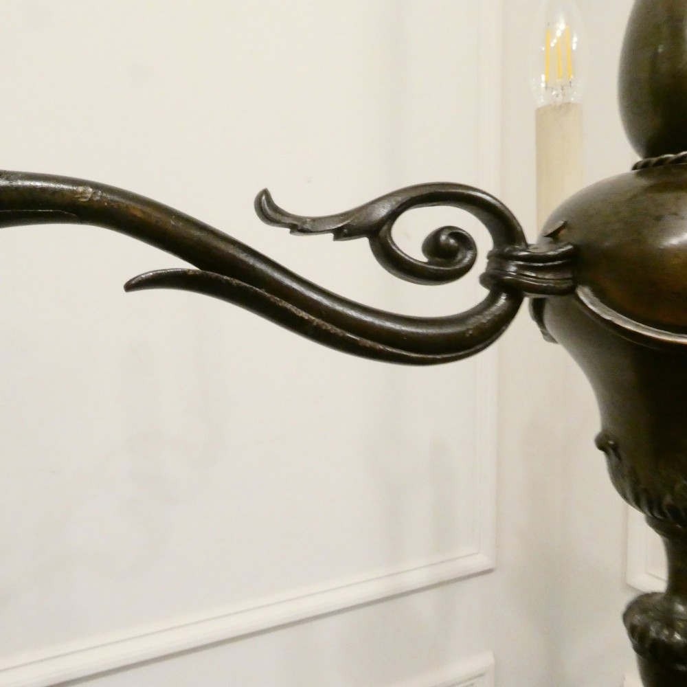 An early 20th-century Dutch bronze two-light chandelier featuring a baluster-turned central stem and curved scrolling arms. View VII