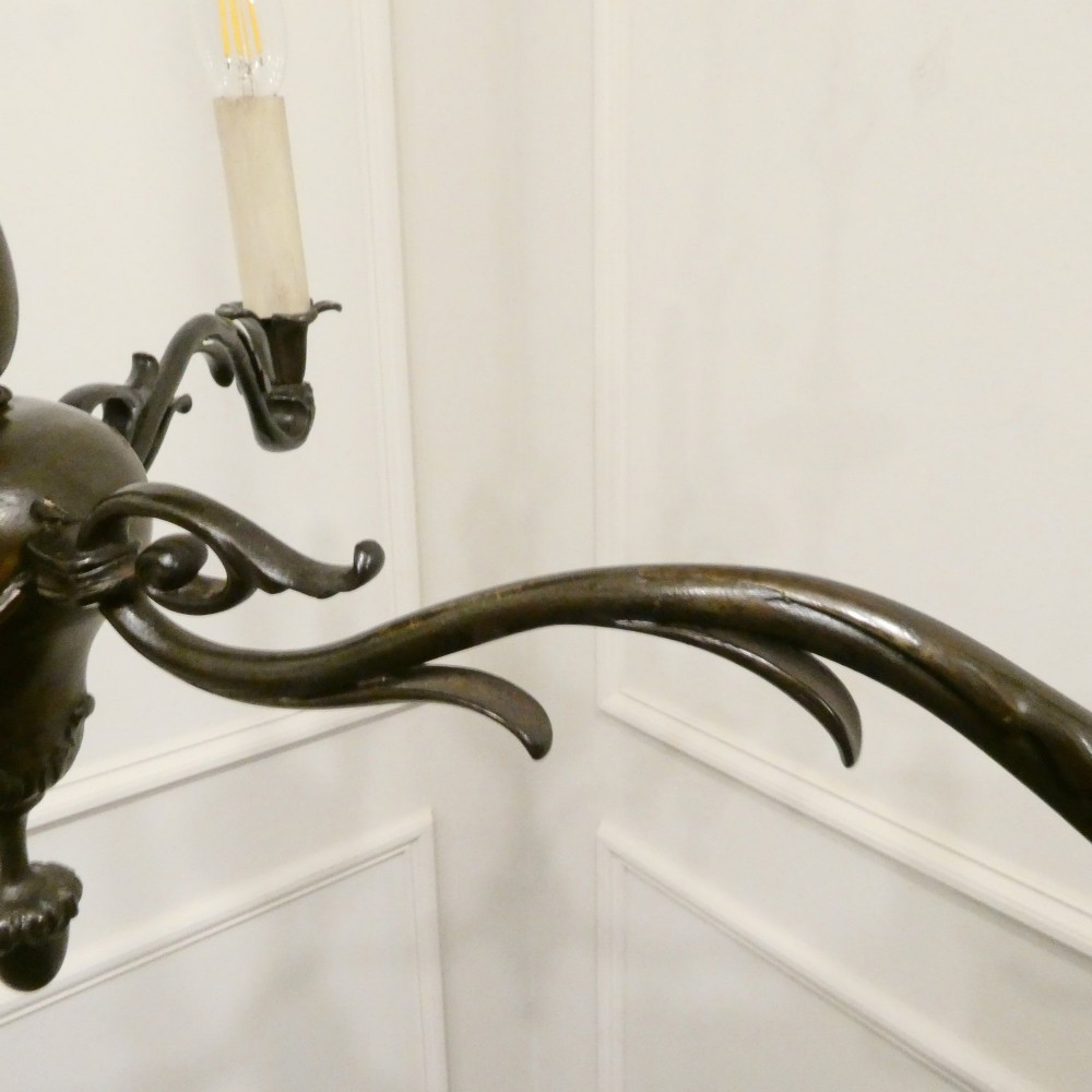 An early 20th-century Dutch bronze two-light chandelier featuring a baluster-turned central stem and curved scrolling arms. View VIII