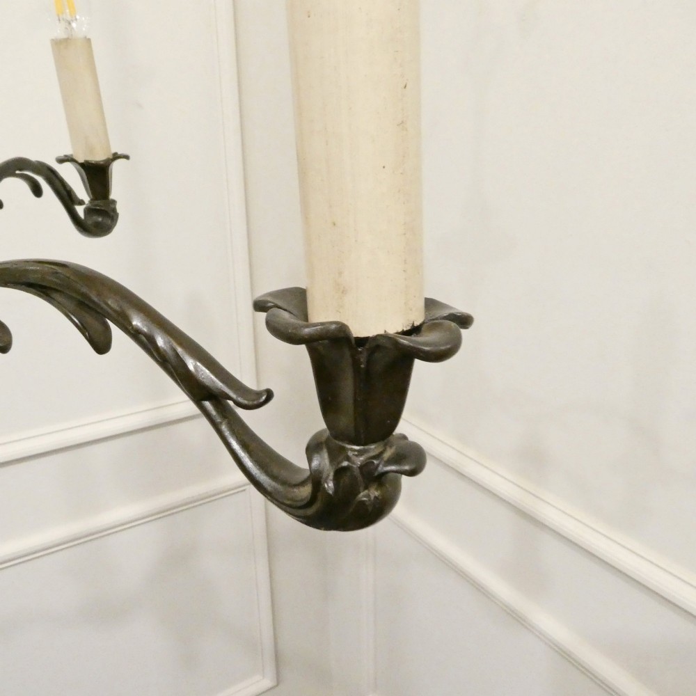 An early 20th-century Dutch bronze two-light chandelier featuring a baluster-turned central stem and curved scrolling arms. View IX
