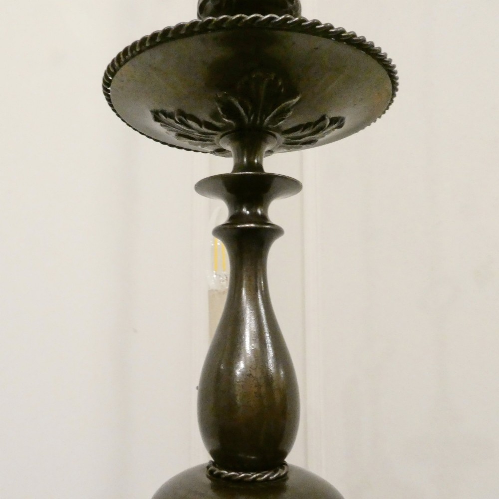 An early 20th-century Dutch bronze two-light chandelier featuring a baluster-turned central stem and curved scrolling arms. View XI