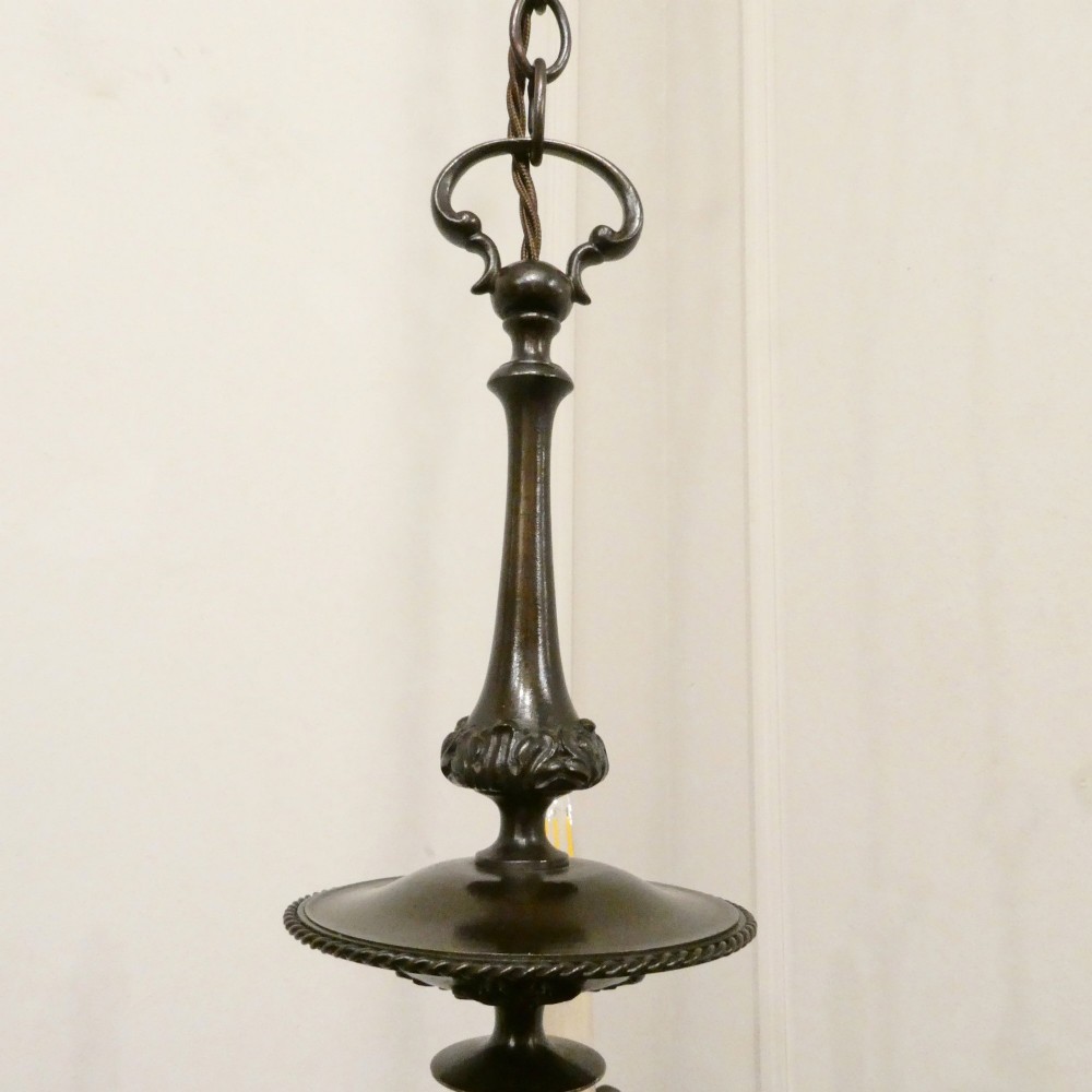 An early 20th-century Dutch bronze two-light chandelier featuring a baluster-turned central stem and curved scrolling arms. View XIII