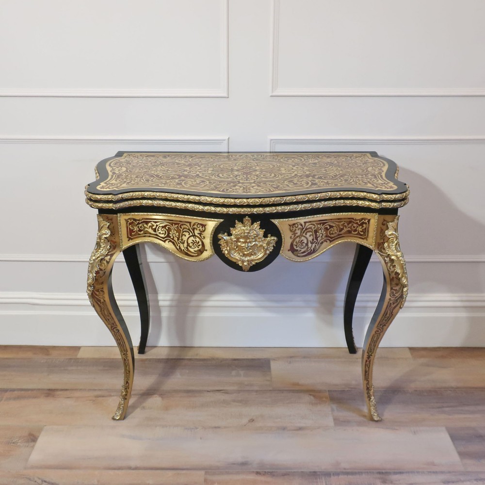 A French Louis XV style Boulle games table featuring brass and tortoiseshell marquetry, gilded ormolu mounts, and cabriole legs. View VI
