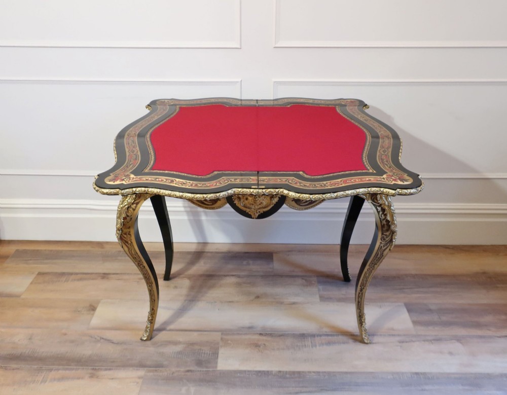A French Louis XV style Boulle games table featuring brass and tortoiseshell marquetry, gilded ormolu mounts, and cabriole legs. View VII