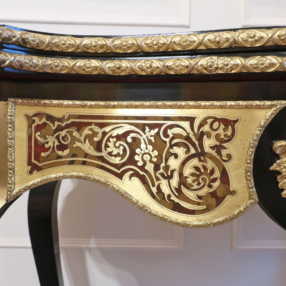 A French Louis XV style Boulle games table featuring brass and tortoiseshell marquetry, gilded ormolu mounts, and cabriole legs. View X