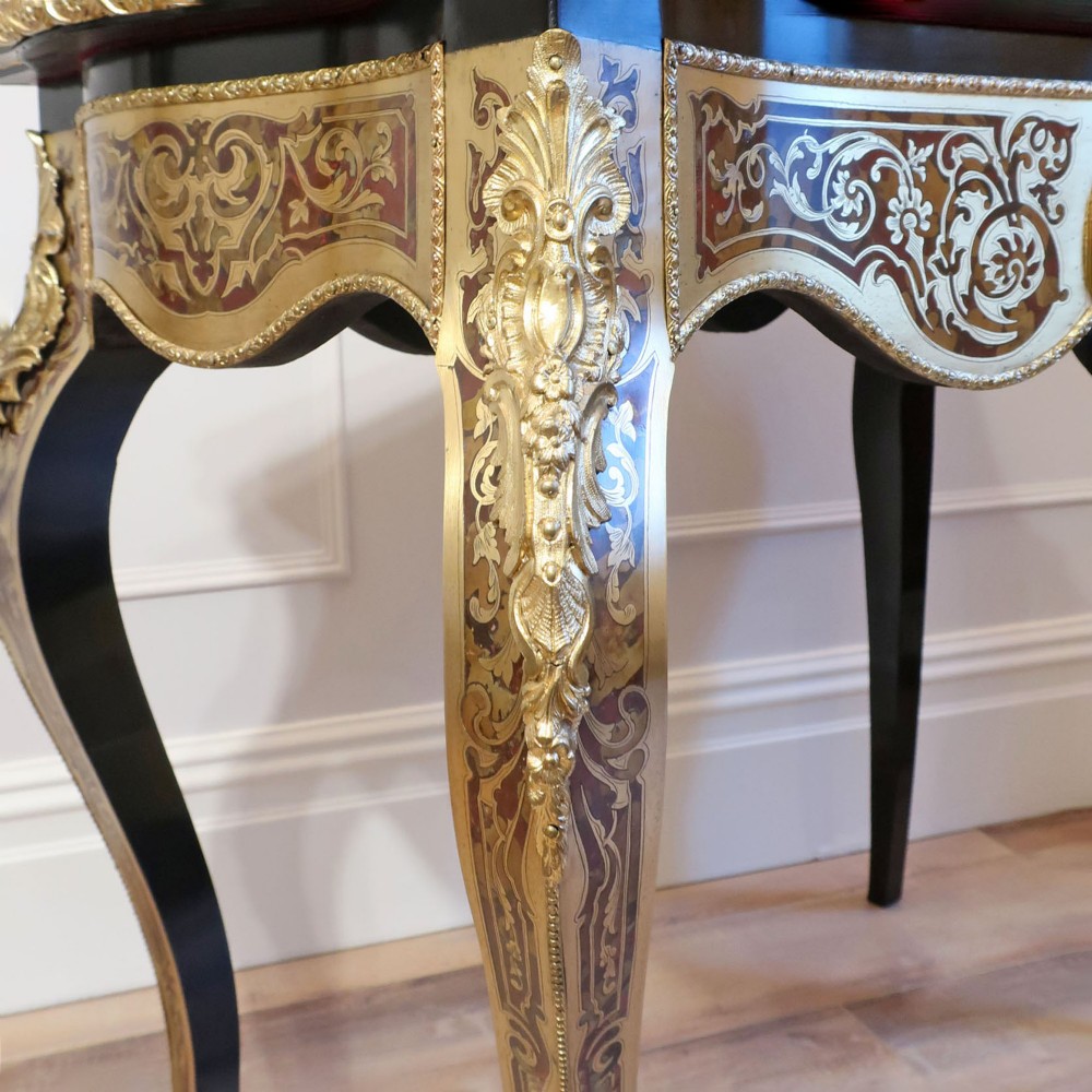 A French Louis XV style Boulle games table featuring brass and tortoiseshell marquetry, gilded ormolu mounts, and cabriole legs. View XI