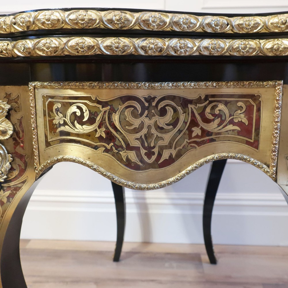 A French Louis XV style Boulle games table featuring brass and tortoiseshell marquetry, gilded ormolu mounts, and cabriole legs. View XIV