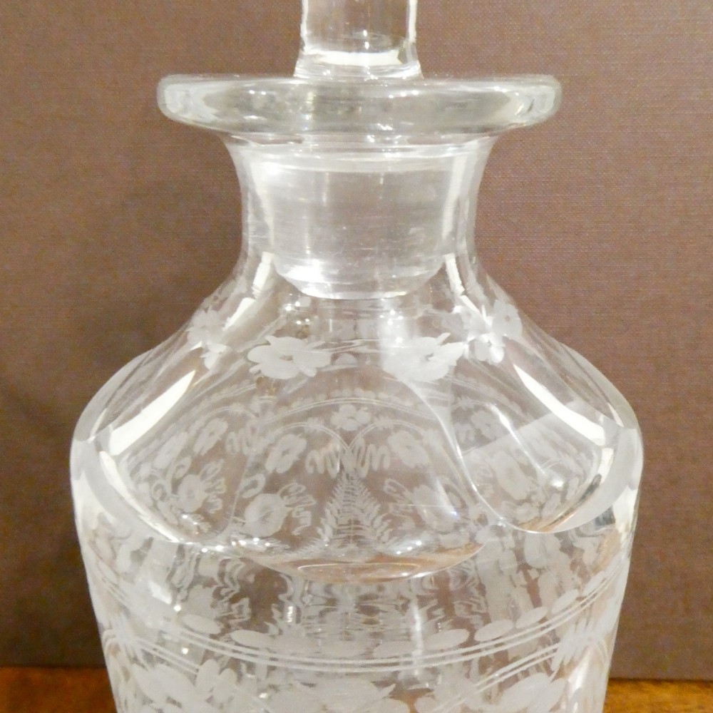 A Victorian silver-plated decanter stand with a central arched handle holding three etched glass decanters with stoppers. View IX