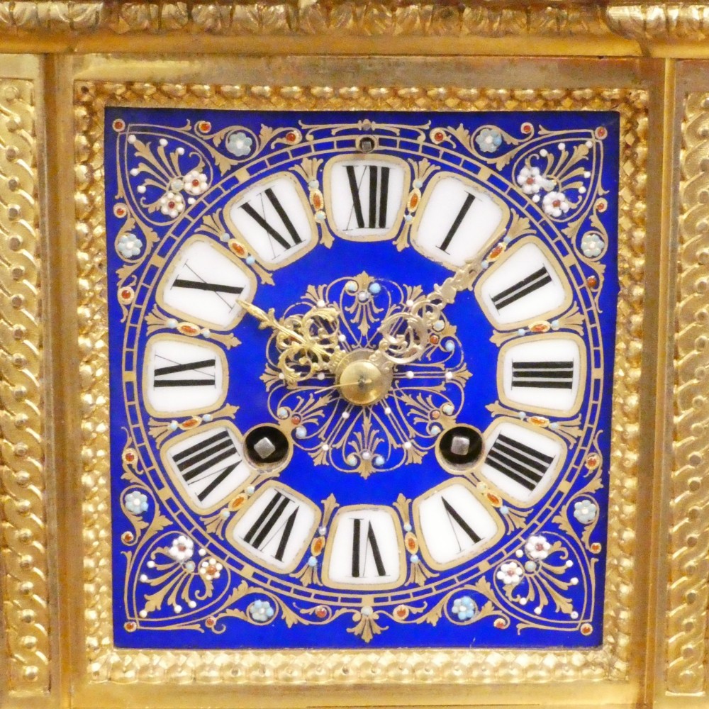 A French gilt bronze mantel clock featuring two cherub figures atop an ornate golden structure with cobalt blue porcelain panels and Roman numerals. View II