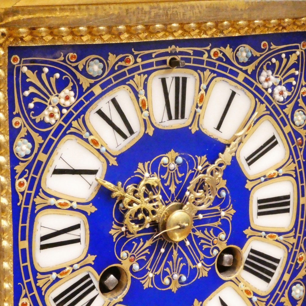 A French gilt bronze mantel clock featuring two cherub figures atop an ornate golden structure with cobalt blue porcelain panels and Roman numerals. View III