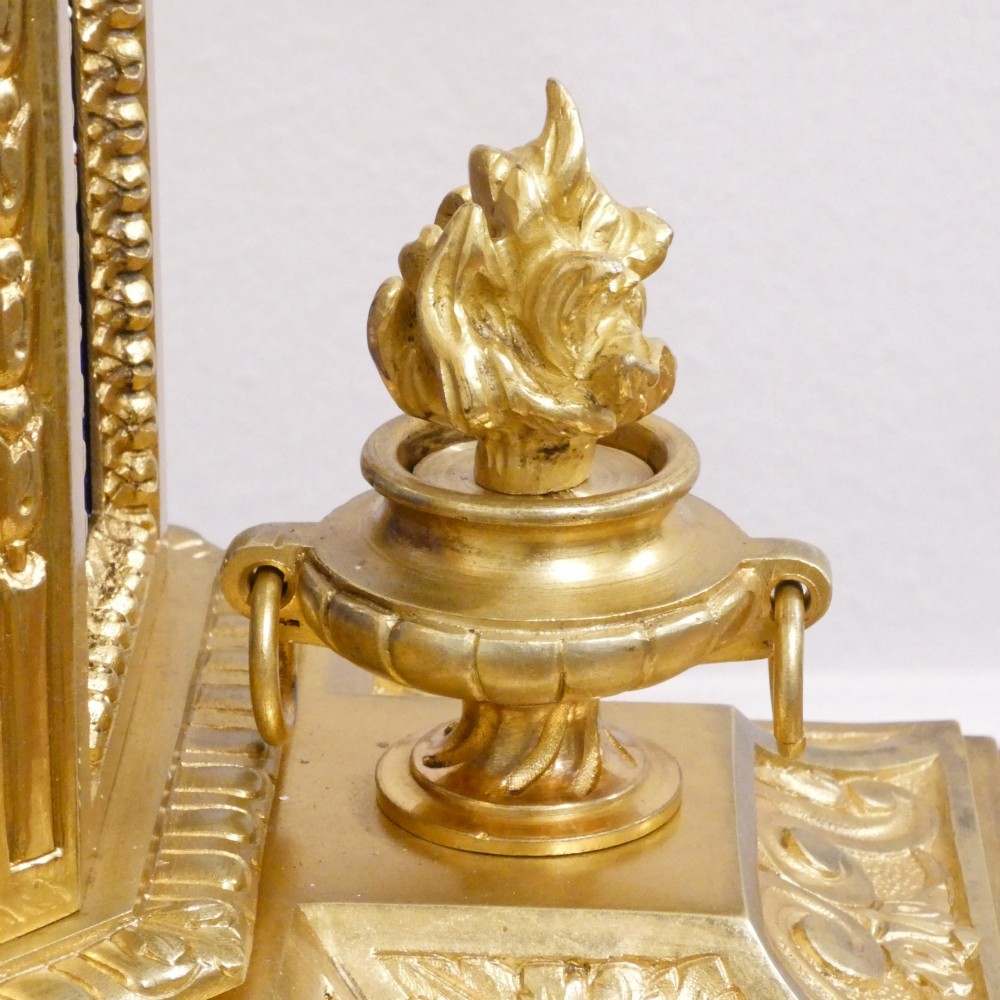 A French gilt bronze mantel clock featuring two cherub figures atop an ornate golden structure with cobalt blue porcelain panels and Roman numerals. View VI