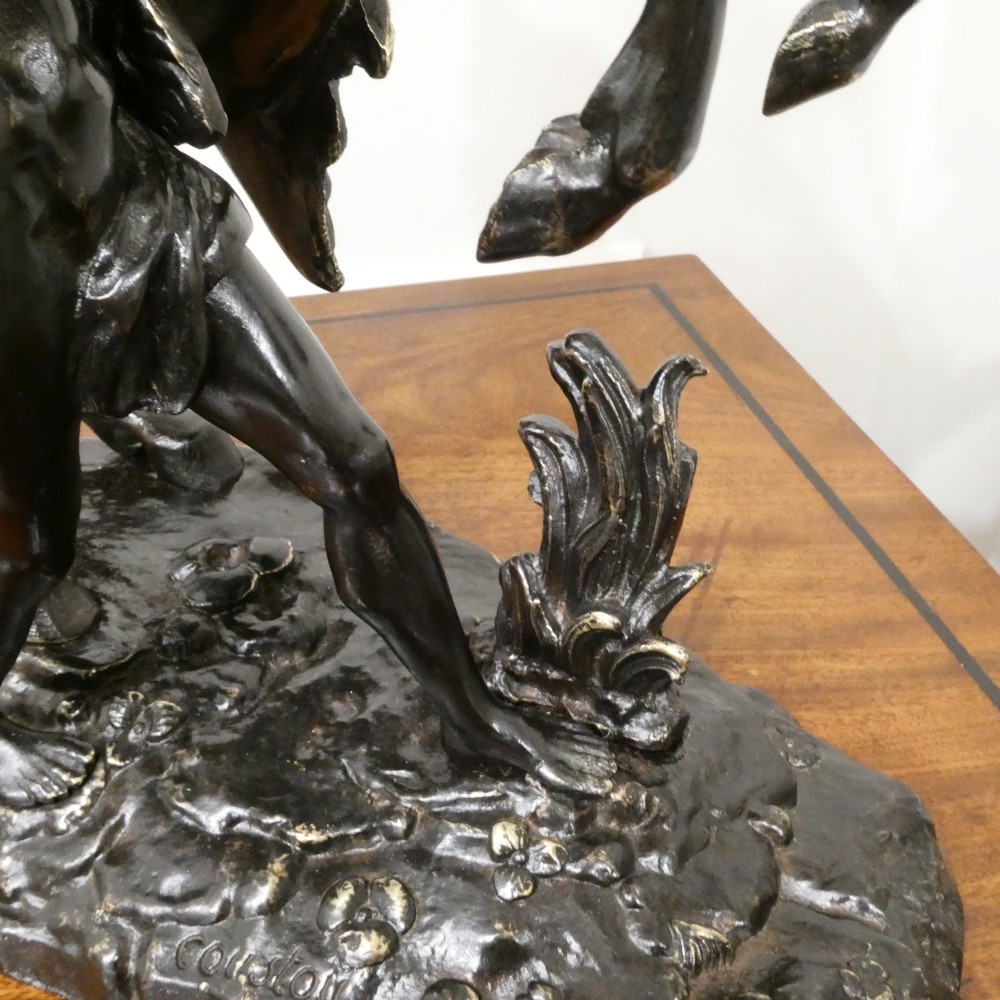 A pair of patinated dark bronze sculptures depicting rearing horses held by grooms on naturalistic bases. View XI