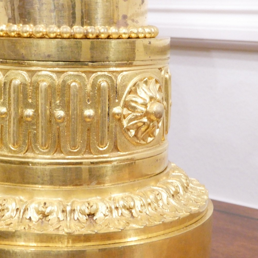 A 19th-century French gilt bronze mantel clock featuring a dark patinated bronze cherub seated beside a circular enamel dial atop a gilt relief base. View XI