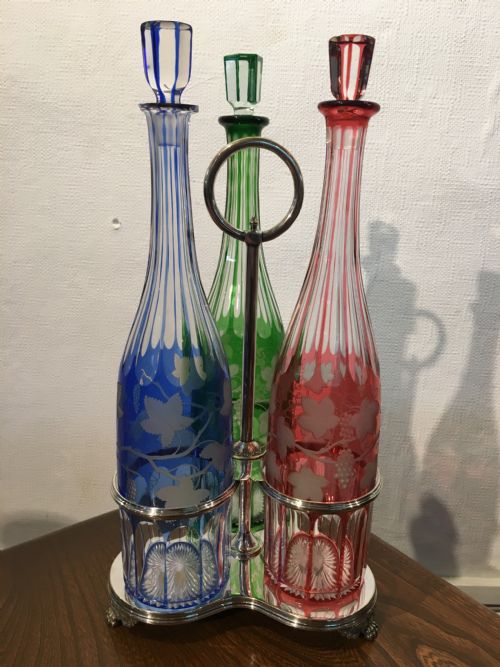 THREE COLOURED TALL CUT VINE GRAPE ENGRAVED DECANTERS IN A HANDLED STAND C1840 - ADDITIONAL PHOTO 1