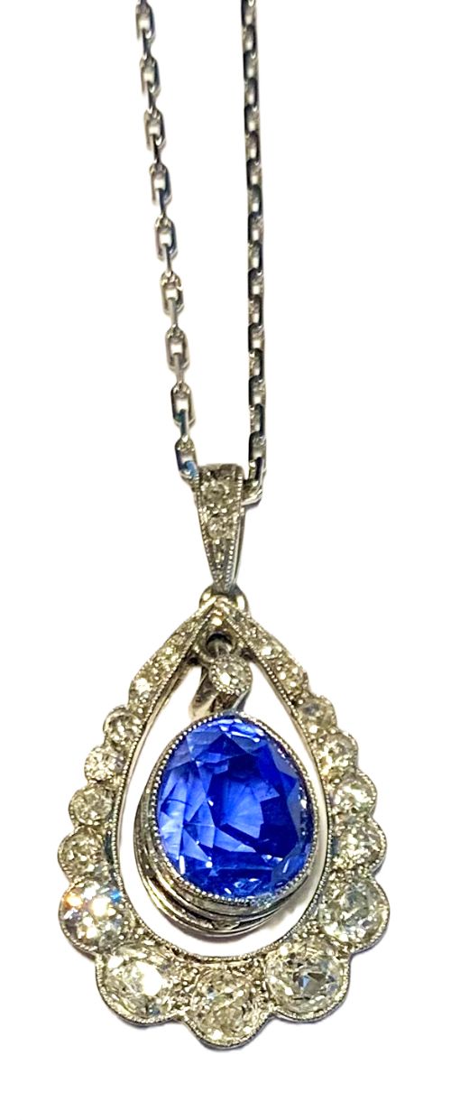 fig 1. A Victorian teardrop pendant set with a central oval cut blue Ceylon sapphire surrounded by a halo of diamonds on a fine silver-tone chain.