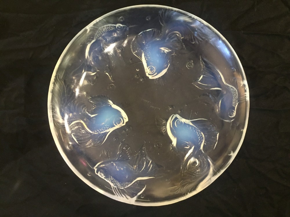 A circular Art Deco opalescent glass charger featuring relief-moulded fish and bubble motifs arranged in a continuous radial pattern.