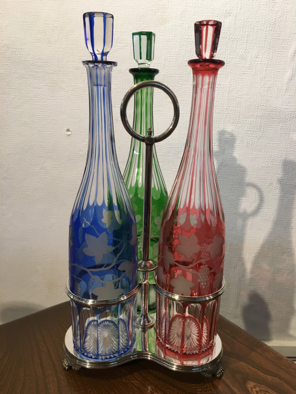 Three Coloured Tall Cut Vine & Grape Engraved Decanters in a Handled Stand c1840 View II