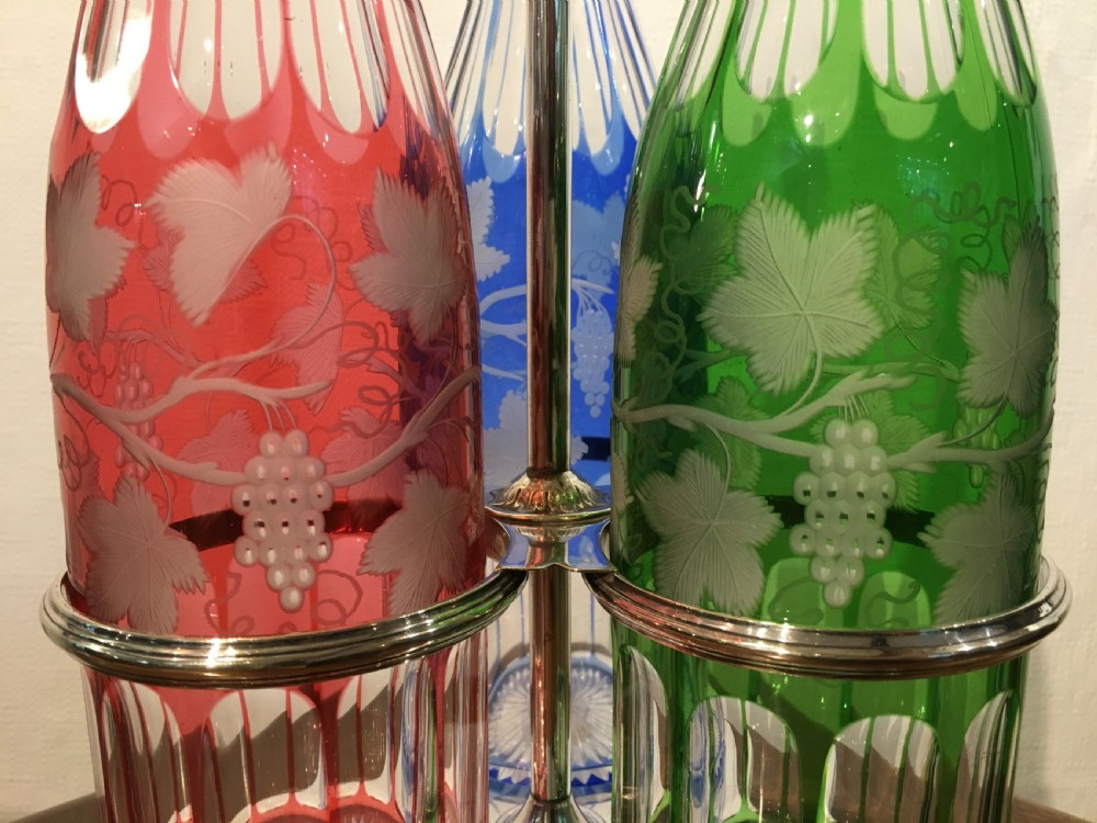 Three Coloured Tall Cut Vine & Grape Engraved Decanters in a Handled Stand c1840 View III