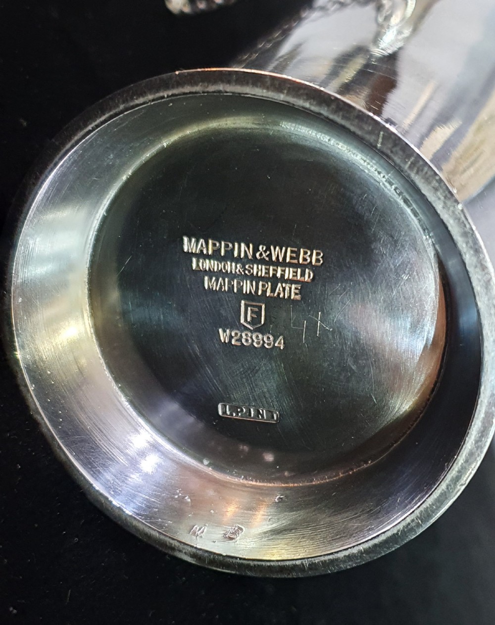 An Art Deco silver-plated cocktail shaker featuring a tapered conical body with turned concentric bands, an angular handle, and a spout with a chained cap stopper. View IX