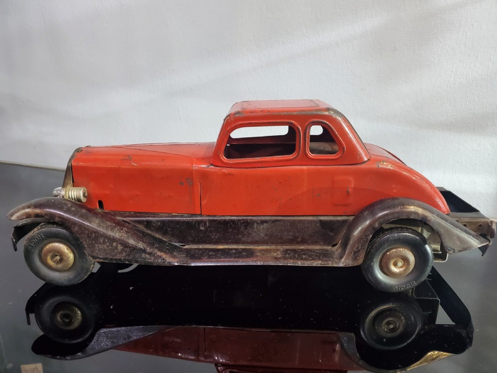 A 1930s red and black pressed steel Fire Chief toy coupe car with clockwork lever and original side decal. View II