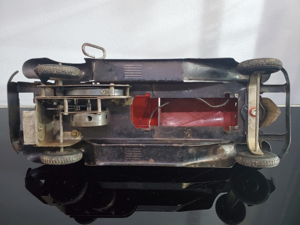 A 1930s red and black pressed steel Fire Chief toy coupe car with clockwork lever and original side decal. View X