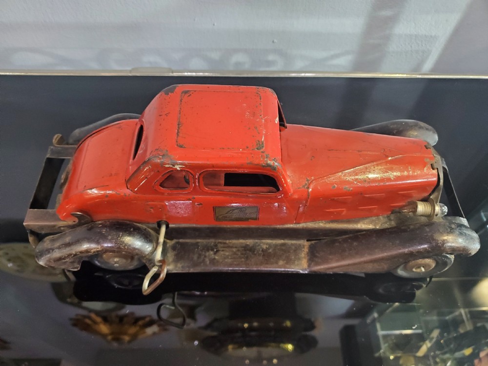 A 1930s red and black pressed steel Fire Chief toy coupe car with clockwork lever and original side decal. View XII