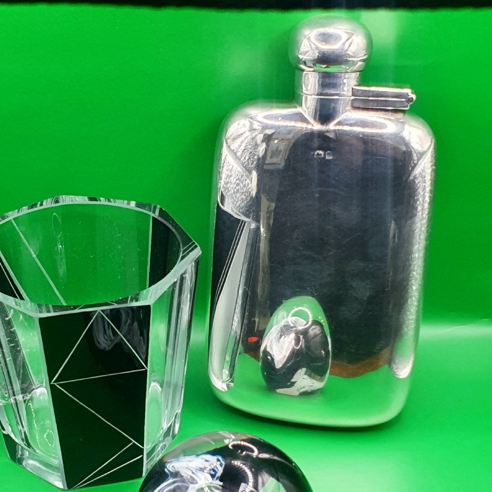 A polished sterling silver hip flask featuring a curved rectangular shape and a hinged bayonet top cap. View VII
