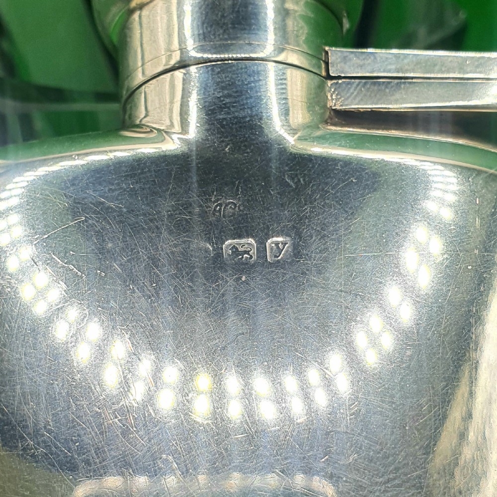A polished sterling silver hip flask featuring a curved rectangular shape and a hinged bayonet top cap. View IV