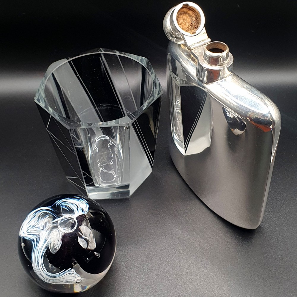 A curved sterling silver hip flask featuring a polished metal surface and a hinged bayonet cap. View II
