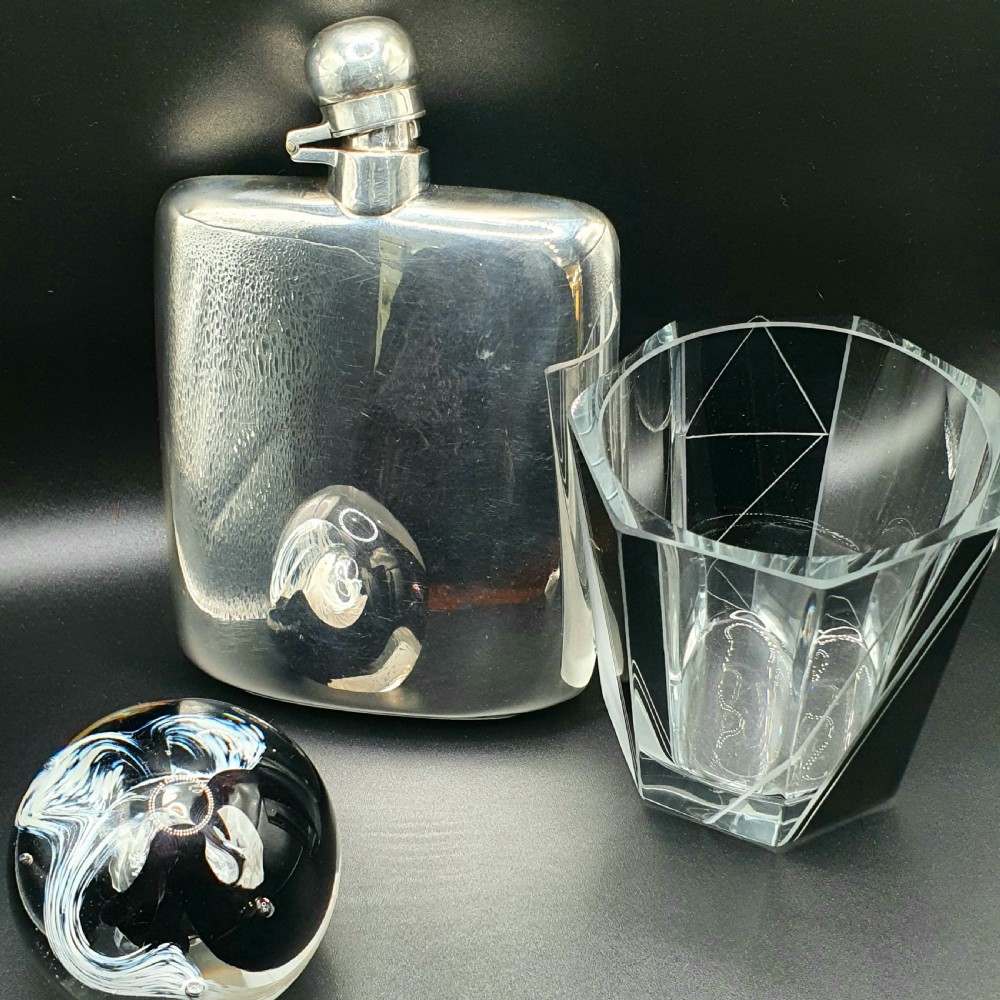 A curved sterling silver hip flask featuring a polished metal surface and a hinged bayonet cap. View VIII