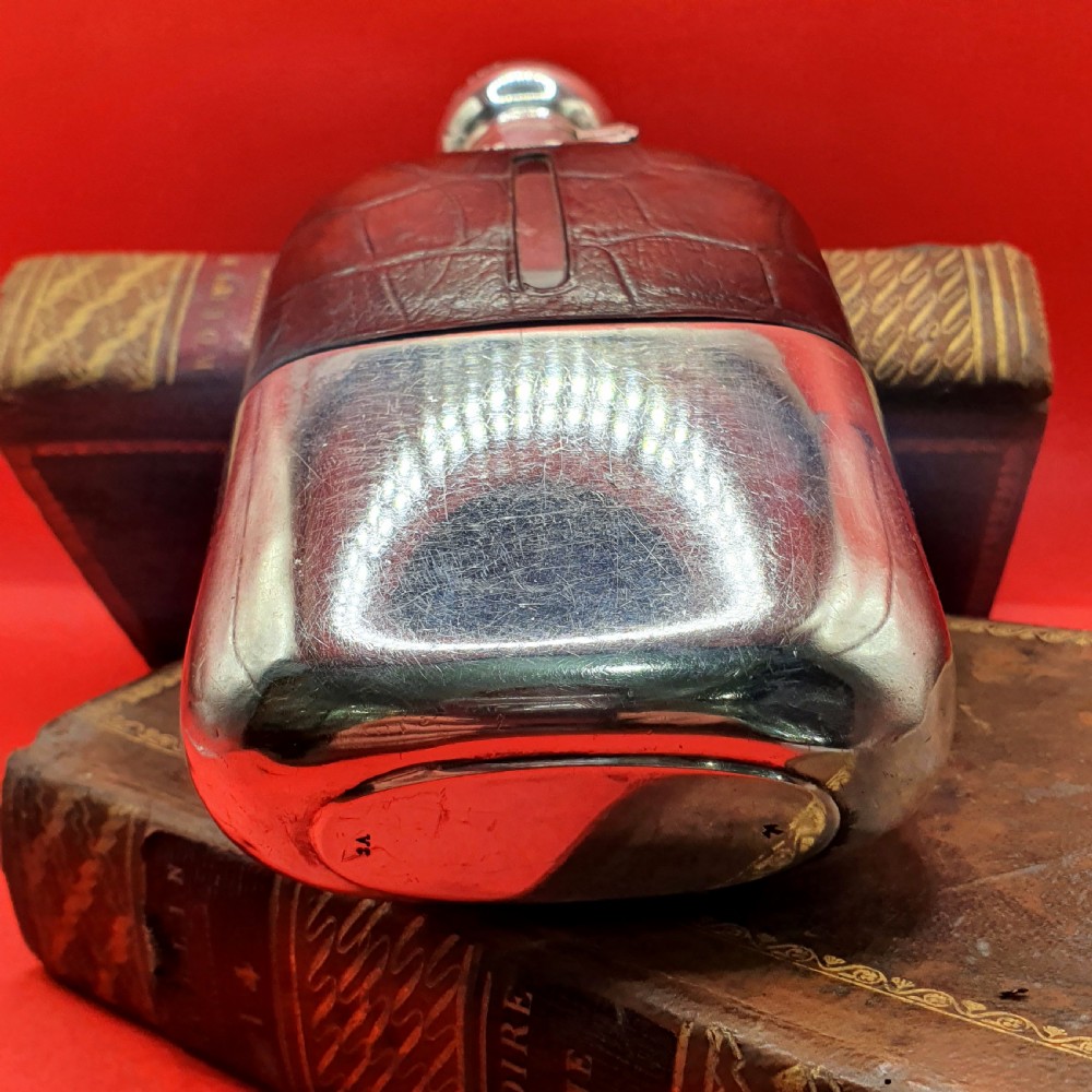 An Edwardian sterling silver hip flask bound in brown crocodile leather featuring a central glass sight window and silver bayonet cap. View III