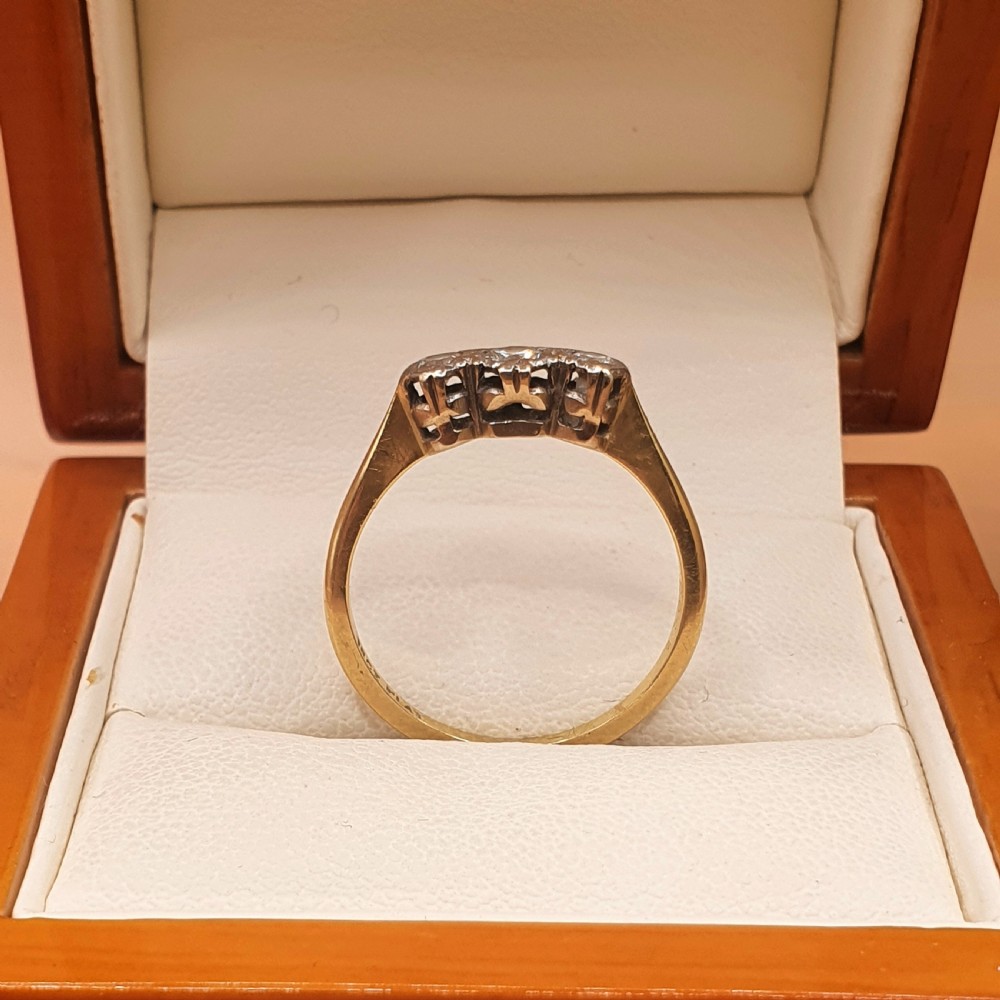 An Art Deco trilogy ring featuring three round diamonds set in a platinum mount on an 18ct yellow gold band. View III