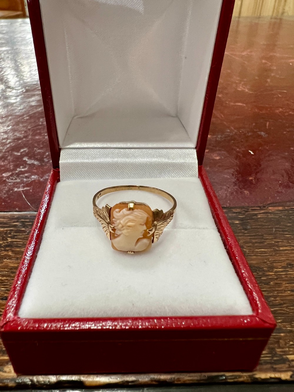 An Art Deco 9ct gold ring featuring a rectangular carved shell cameo displaying a female profile in relief.