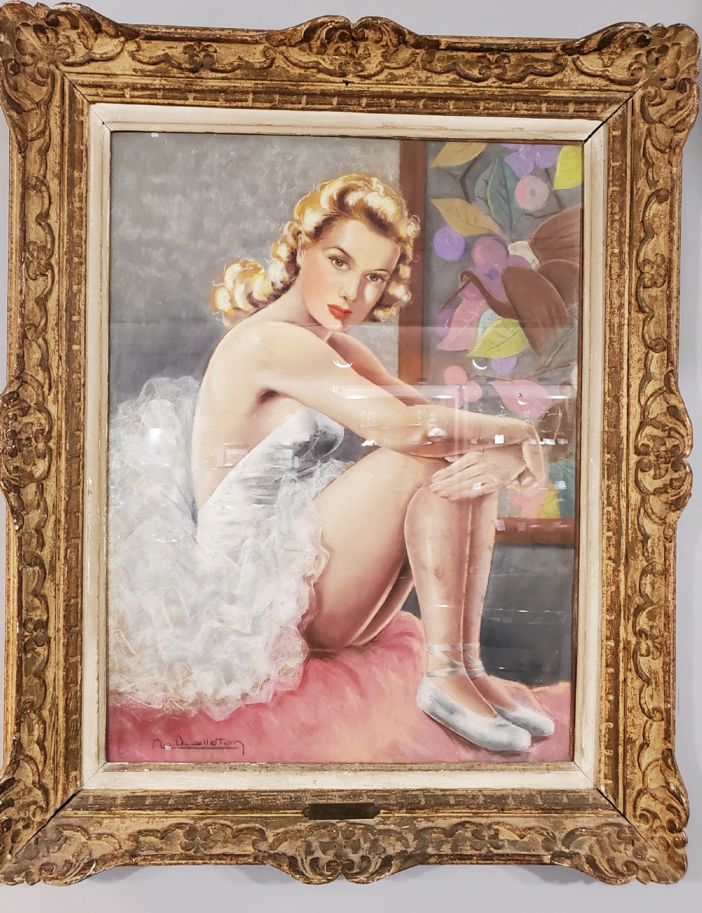 An Art Deco framed pastel portrait on board depicting a seated ballerina in a white tutu within a carved gold frame.