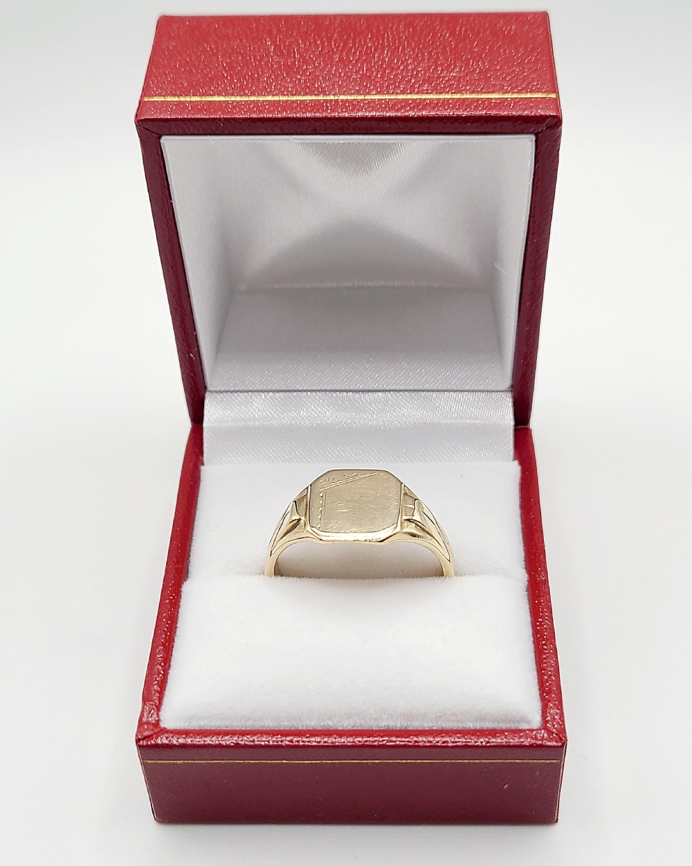 An Art Deco 9ct yellow gold signet ring featuring a flat hexagonal bezel with linear engraved details on the top edge and shoulders. View III