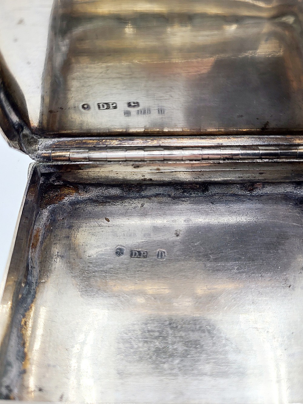 An ornate rectangular Victorian silver table snuff box featuring serpentine edges, hand-engraved scrollwork borders, and a plain polished central panel on the hinged lid. View XII