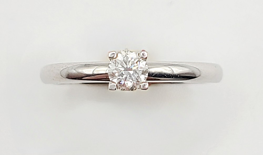 A top-down view of a round brilliant cut diamond set in a four-claw platinum band.