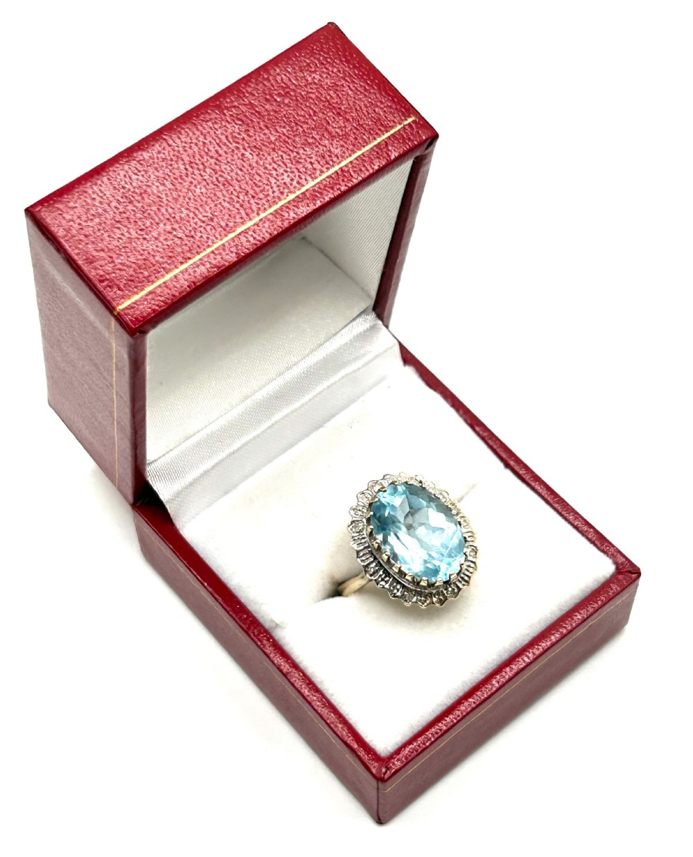 A vintage 9ct gold ring featuring a large oval light blue topaz surrounded by a halo of small diamonds.