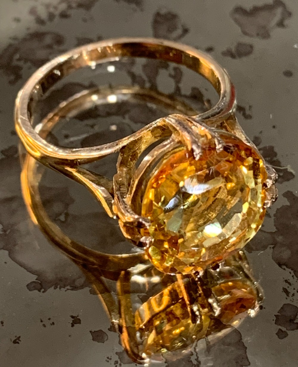 An Art Deco period 9ct gold solitaire ring featuring a large faceted orange synthetic sapphire held in claw settings. View VII