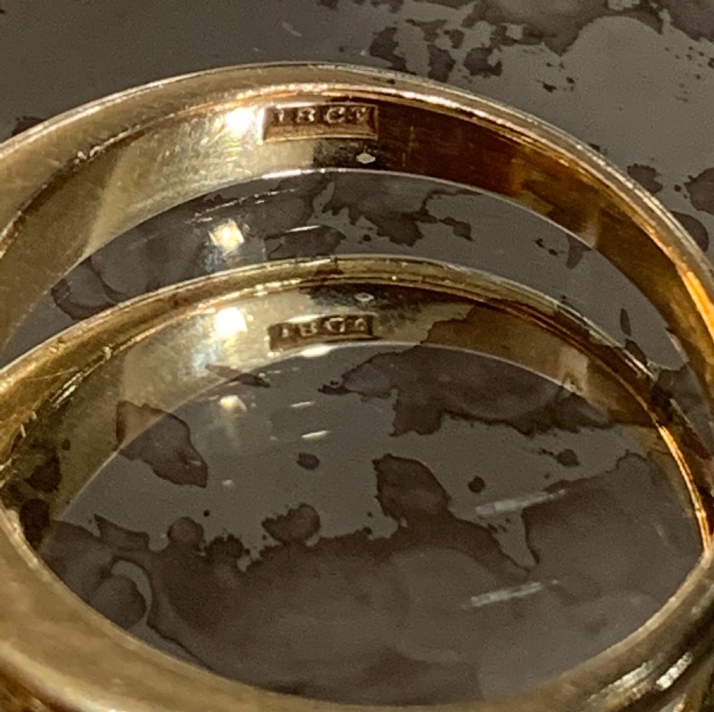 A solid 18ct yellow gold band ring featuring three flush-set round diamonds across the top profile. View V