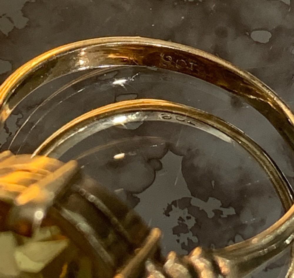 An Art Deco 9ct yellow gold solitaire ring featuring a large round old-cut yellow citrine gemstone held in a multi-claw setting with stepped shoulders. View V