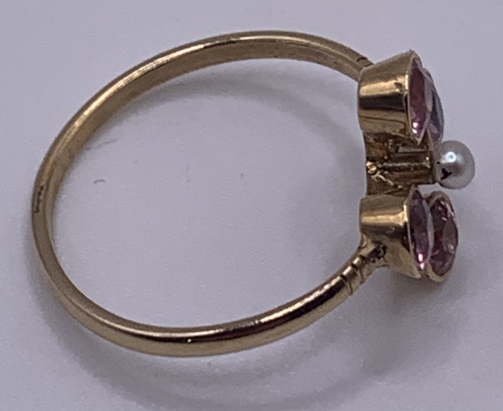 A Victorian 15ct gold ring featuring four circular pink tourmalines bezel-set around a central seed pearl. View II