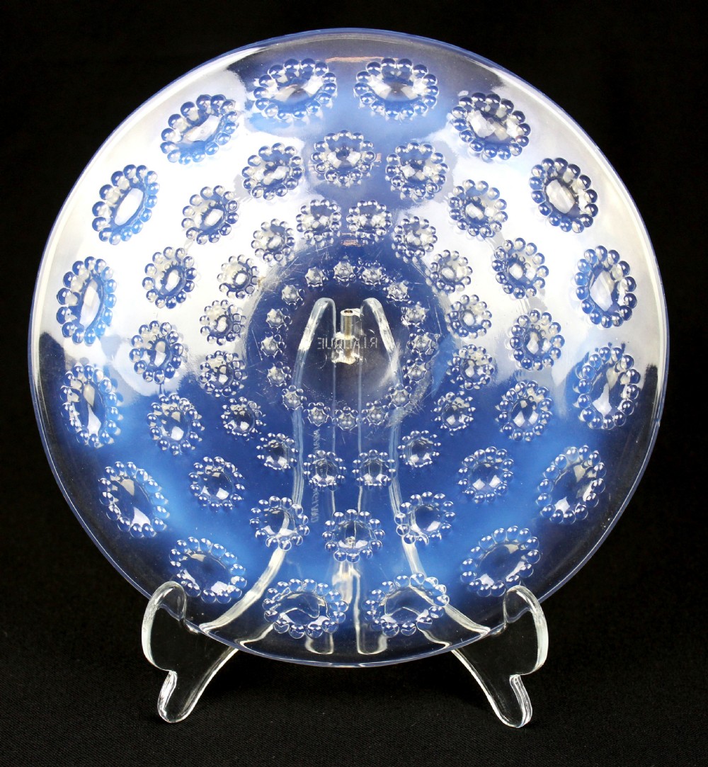 A circular Art Deco opalescent glass bowl featuring concentric moulded aster flower head motifs against a translucent light blue hue.