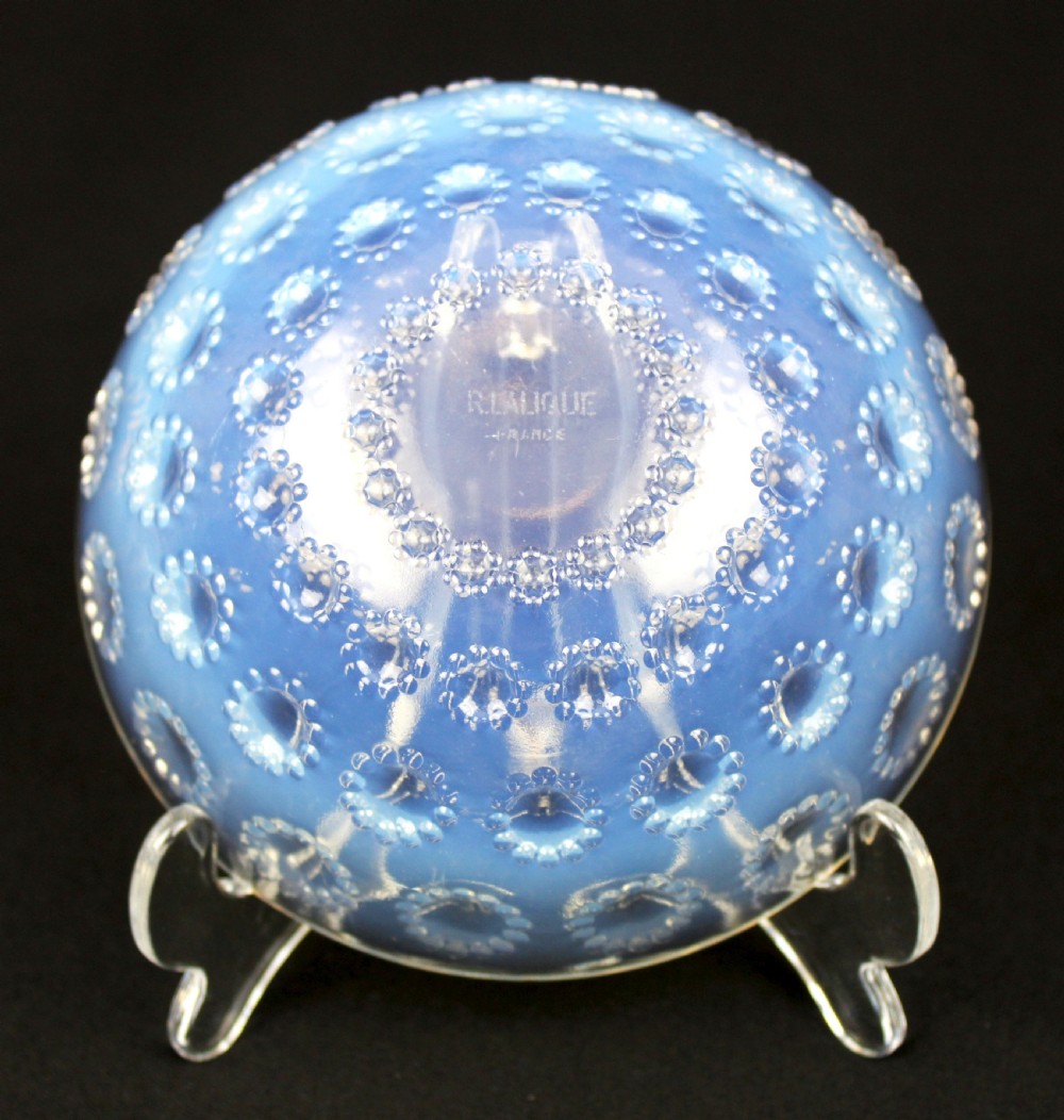 A circular Art Deco opalescent glass bowl featuring concentric moulded aster flower head motifs against a translucent light blue hue. View V