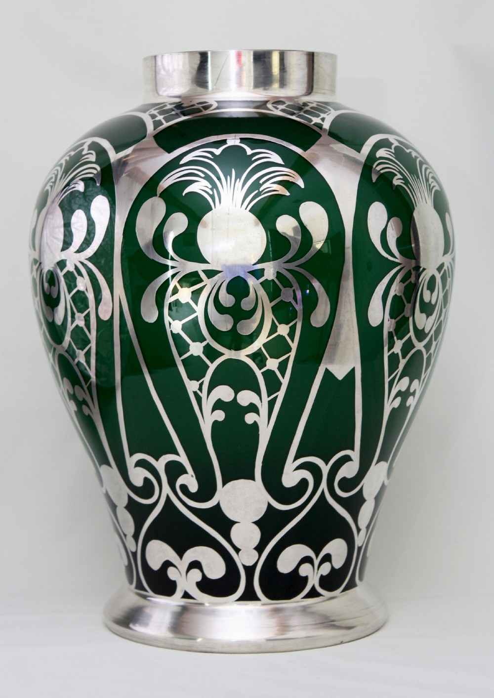 A deep green glass vase adorned with intricate sterling silver overlay featuring stylised foliage and lattice patterns. View III