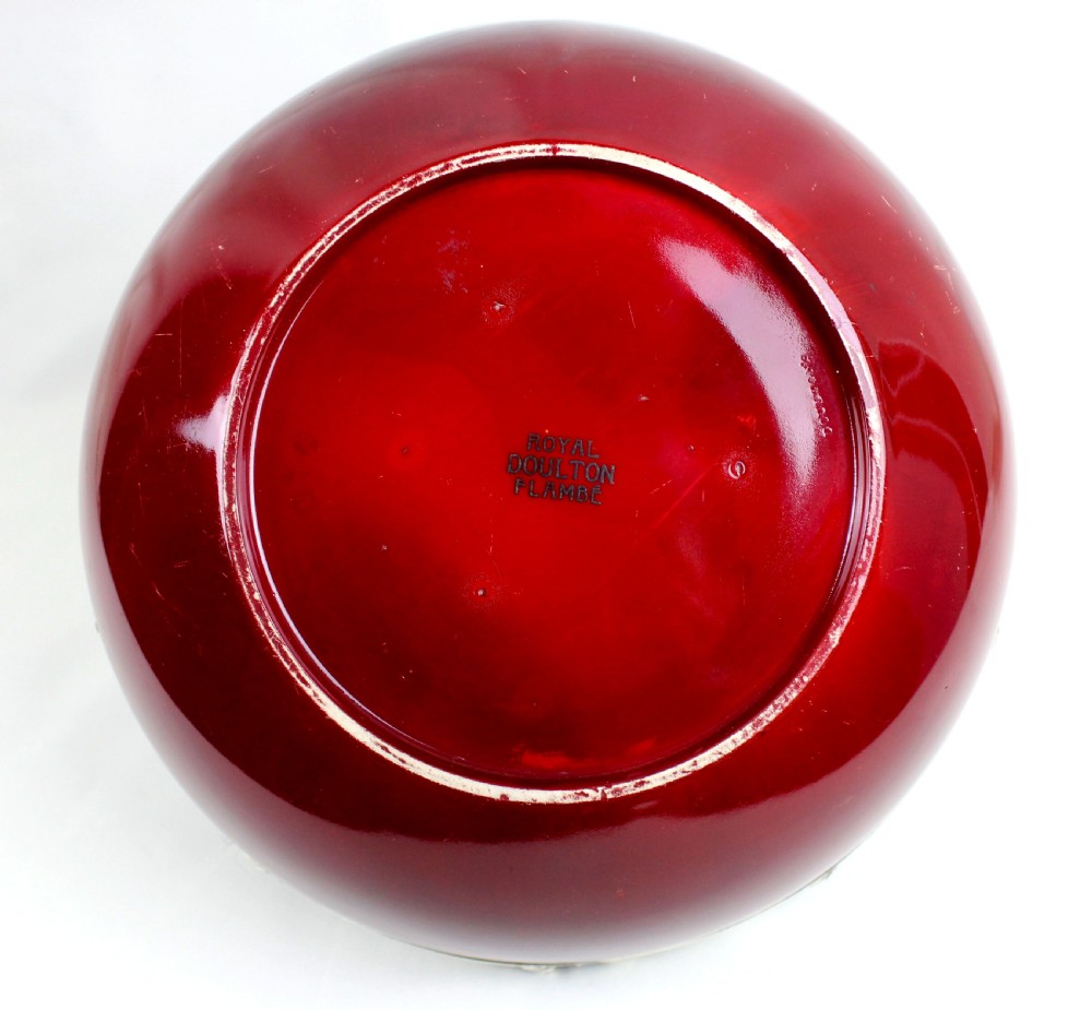 A deep circular red flambe ceramic bowl featuring a thick repousse sterling silver rim with floral and scroll reliefs. View V