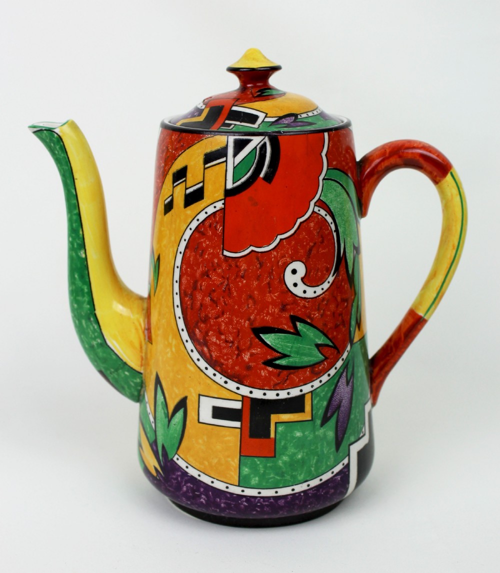 A multi-piece Art Deco ceramic coffee set decorated with vibrant red, yellow, green, and black abstract geometric patterns, comprising a tall coffee pot, creamer, sugar bowl, six demitasse cups, and matching saucers. View II